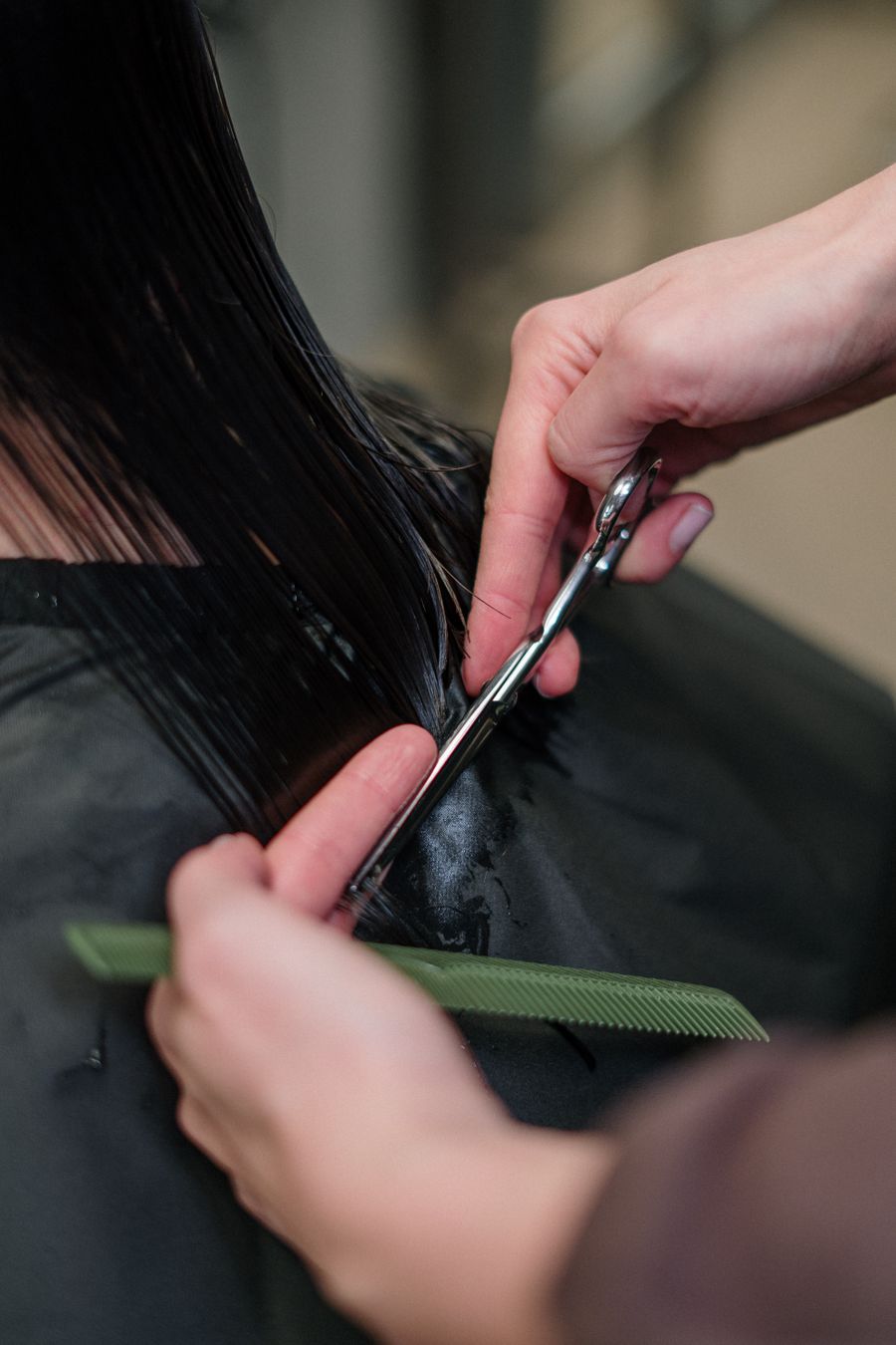 Stylist cutting a client's dark hair